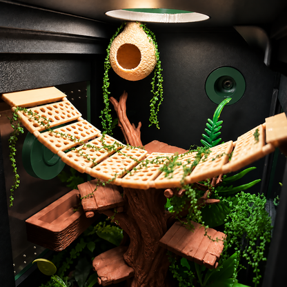 A detailed view of a naturalistic animal enclosure interior, likely for a bearded dragon or similar reptile, featuring a curved wooden climbing ramp, a hanging woven nest pod, green artificial vines, and a textured brown tree trunk with small platforms and foliage.